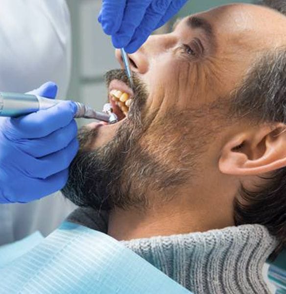 Dentist providing dentistry services for male patient