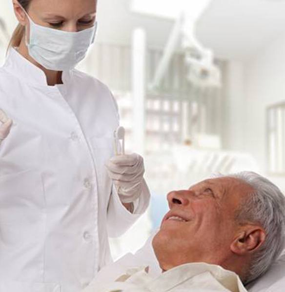 Dentist giving senior man the okay after oral cancer screening