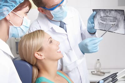 Woman and dentist looking at x-rays before tooth extraction