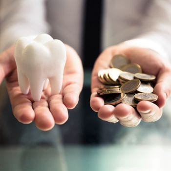 Hand holding an animated tooth and coins