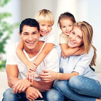 Smiling family with healthy teeth relaxing at home