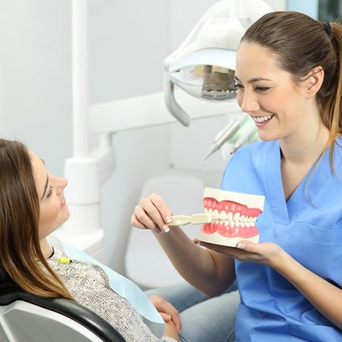 Dental hygienist showing a patient in Powdersville how to brush