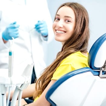 Woman smiling in dental chair looking back at camera