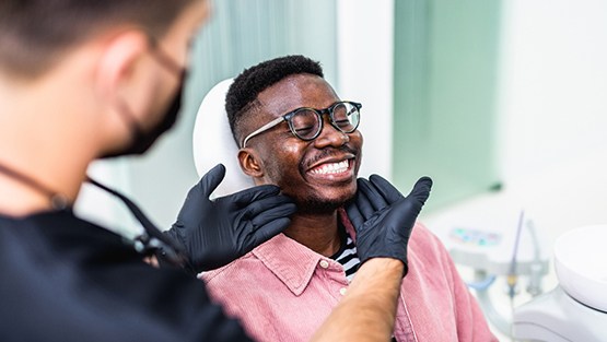 Dentist looking at smiling's patients teeth