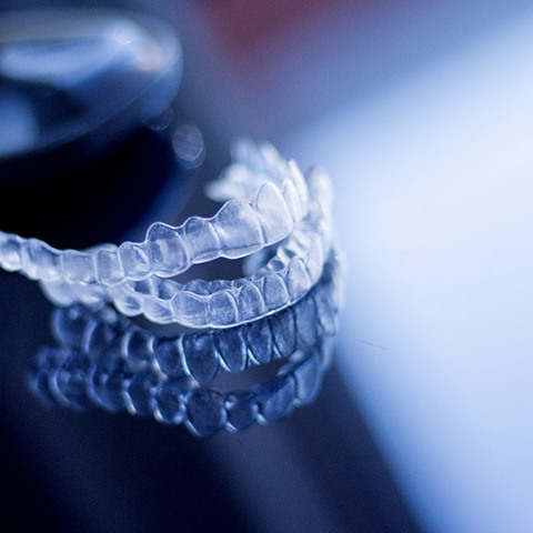 a woman putting aligners in her mouth