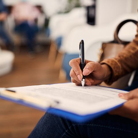 a person filling out forms on a clipboard