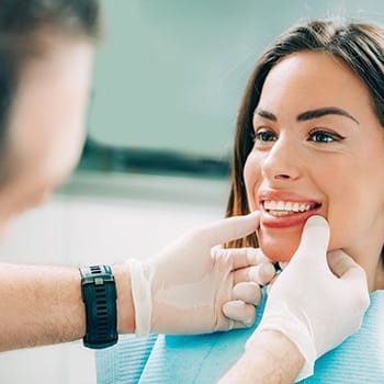 Dentist examining woman's smile