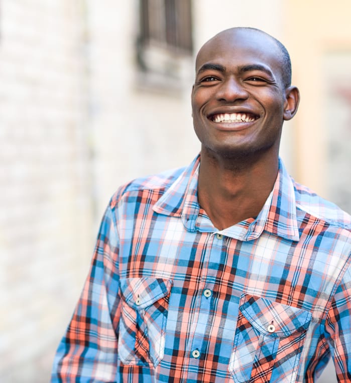 Man smiling after receiving a dental crown restoration