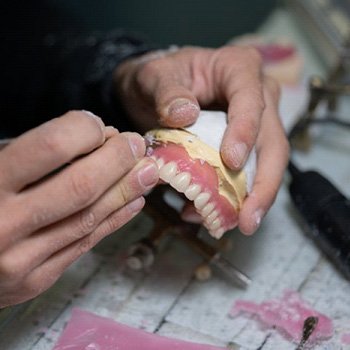a technician working on the denture creation process