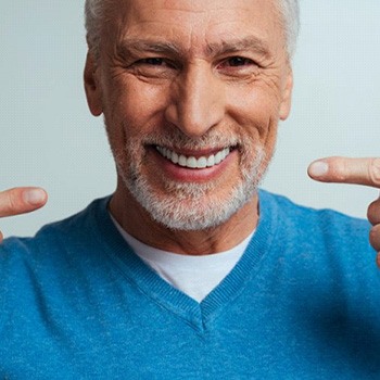 a man pointing at his brand new dentures