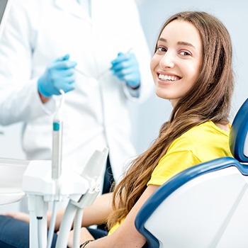 Female dental patient in yellow shirt visiting dentist
