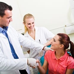 Dentist and patient shake while discussing payment for dentistry