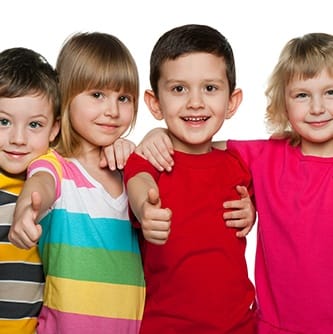 Four kids giving the thumbs up after children's dentistry appointment