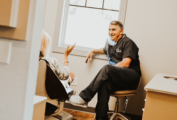 Dentist talking to patient in dental exam room