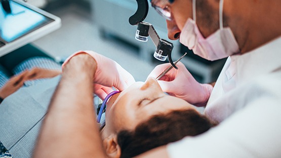 A dentist performing a root canal on a patient