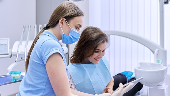 A woman using a tablet to pay for her dental care