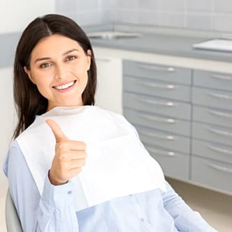 Female patient giving thumbs up for restorative dentistry