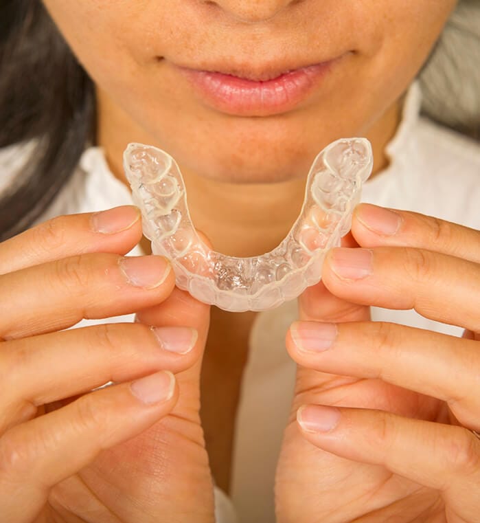 Woman placing ClearCorrect aligner tray