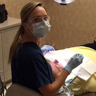 Dental team member performing oral cancer screening