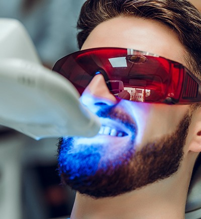 A man getting teeth whitening at a dentist’s office