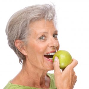 older woman preparing to eat apple