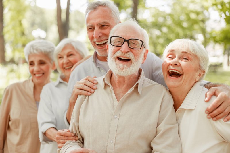 a group of older individuals showing off their new dental implants in Simpsonville