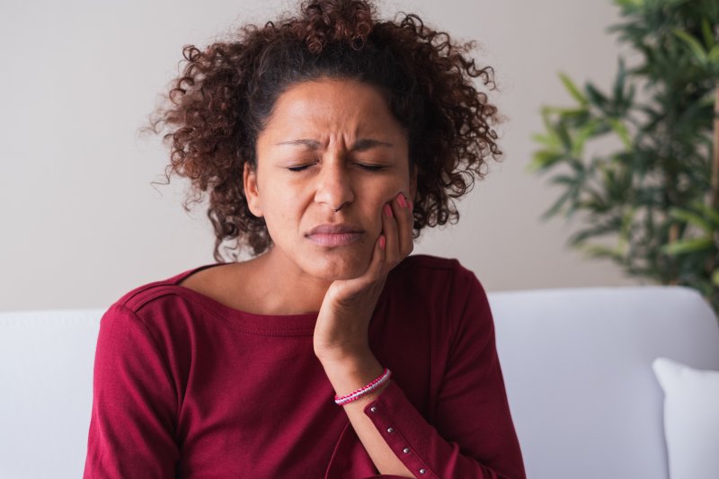 person with dental emergency holding cheek