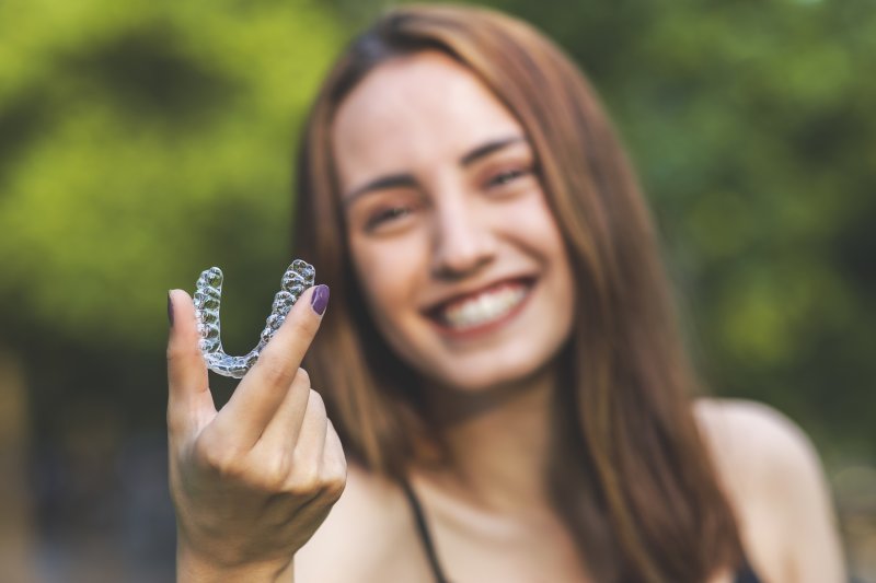 person holding clear aligner tray 