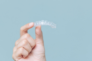 a person holding a clear aligner