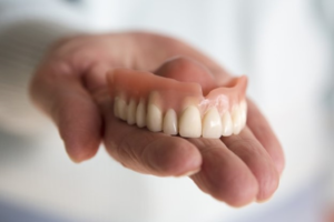 a closeup of a person holding their dentures