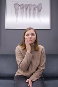Woman in pain sitting at an emergency dentist
